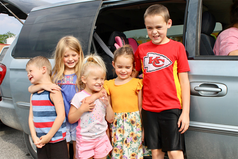 Kids standing by van